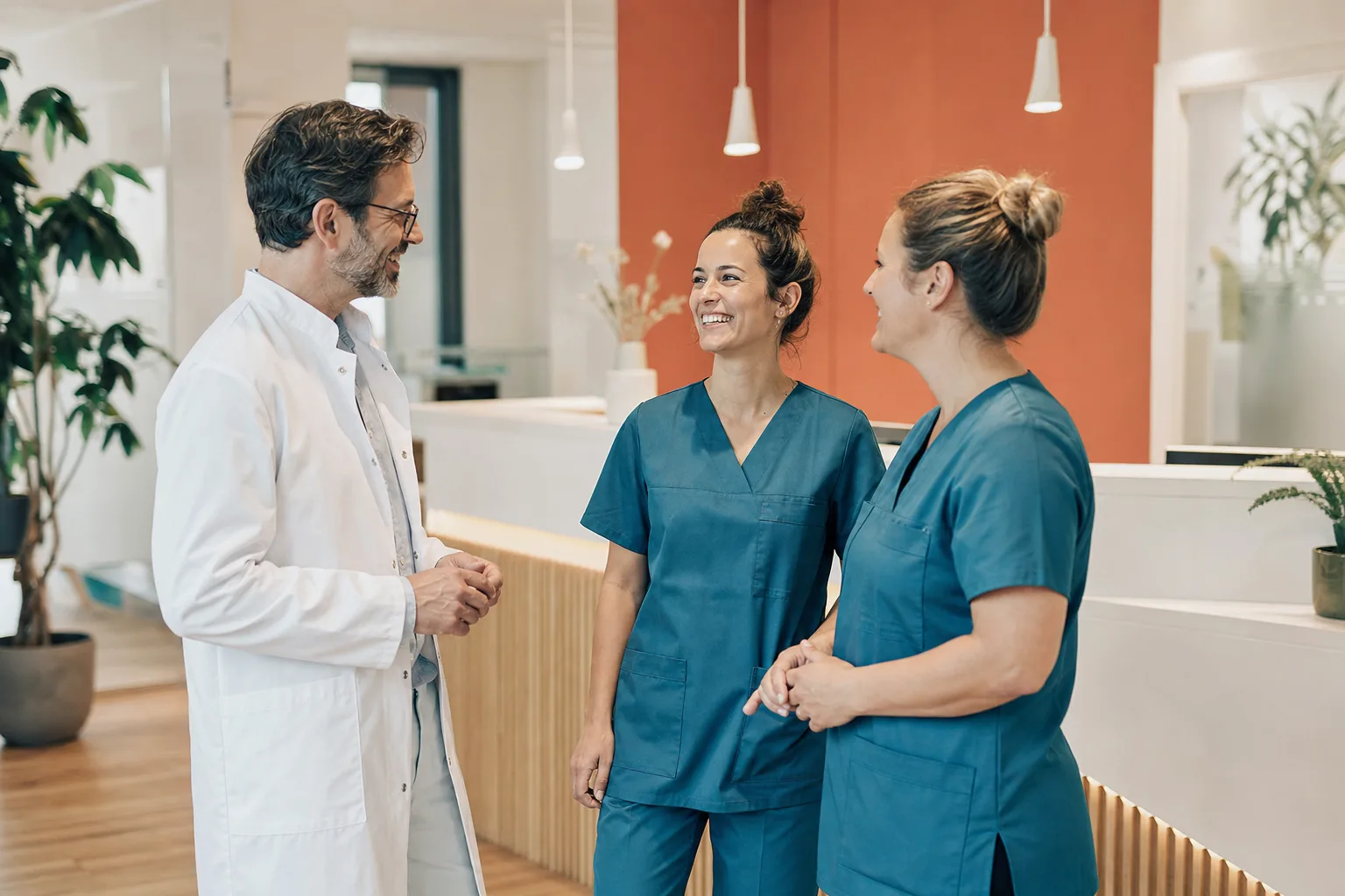 Praxis-Team aus Ärztin und zwei medizinischen Fachangestellten im Gespräch
